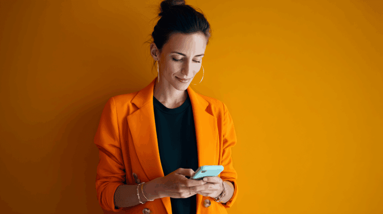 a woman in orange jacket looking at a phone