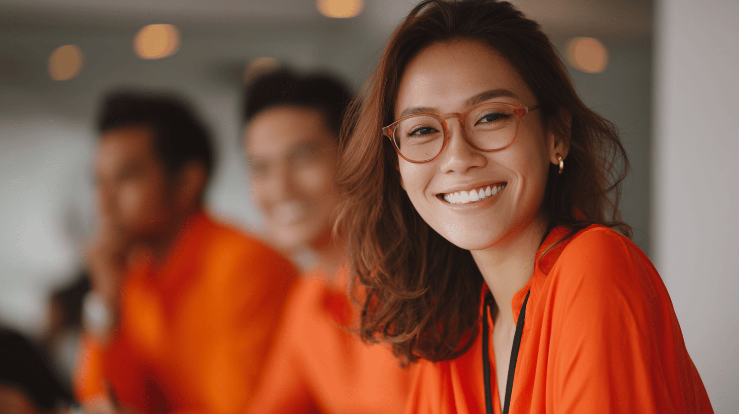 People in orange attire at meeting.