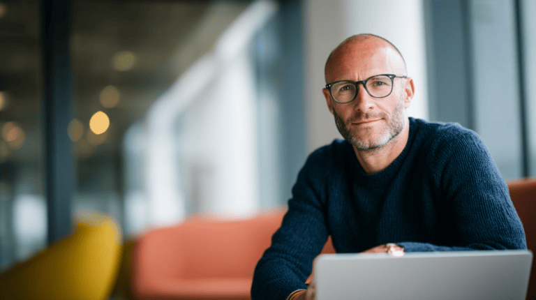 Man with glasses sitting indoors