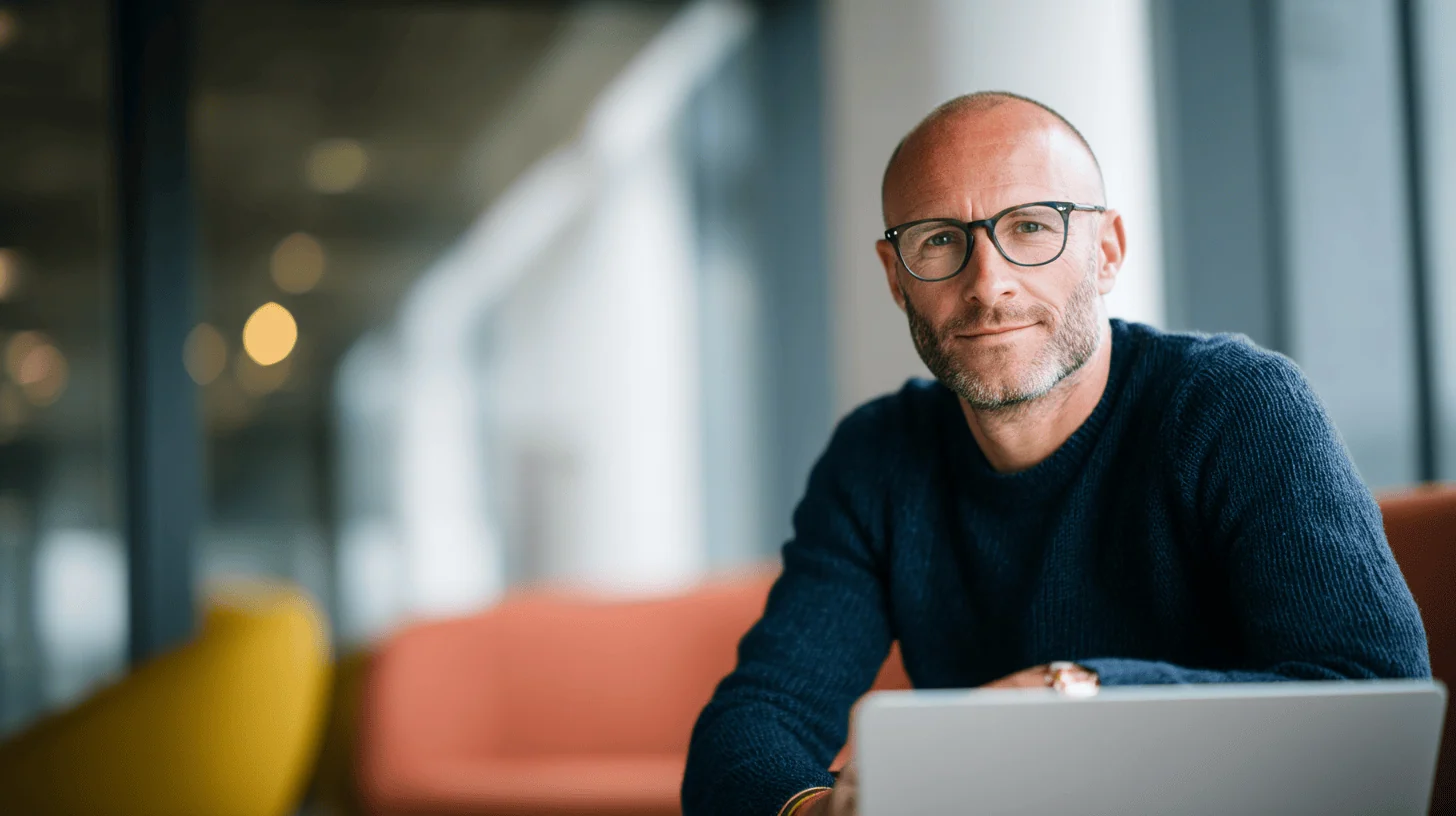 Man with glasses sitting indoors