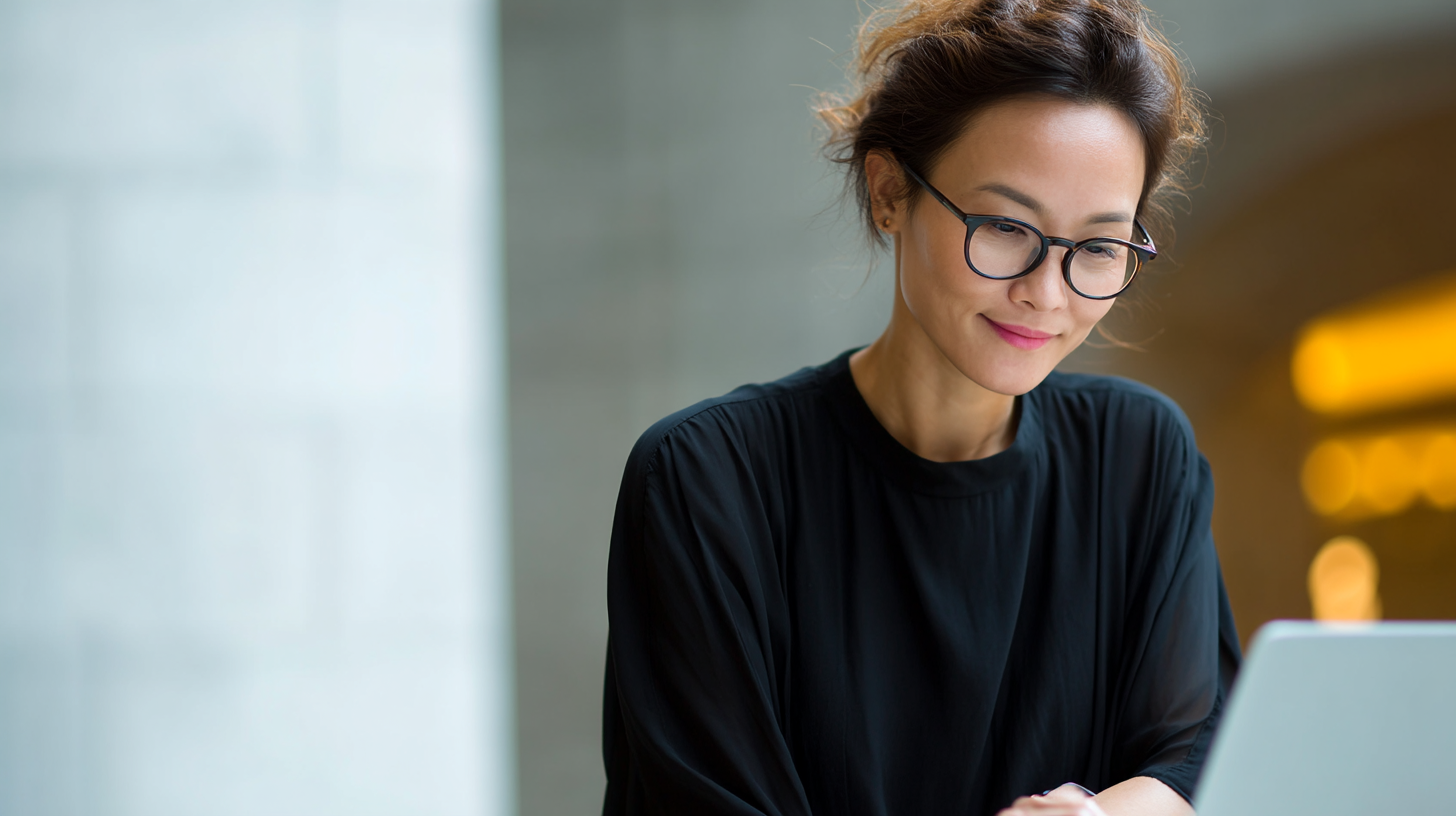 Woman working on laptop, smiling