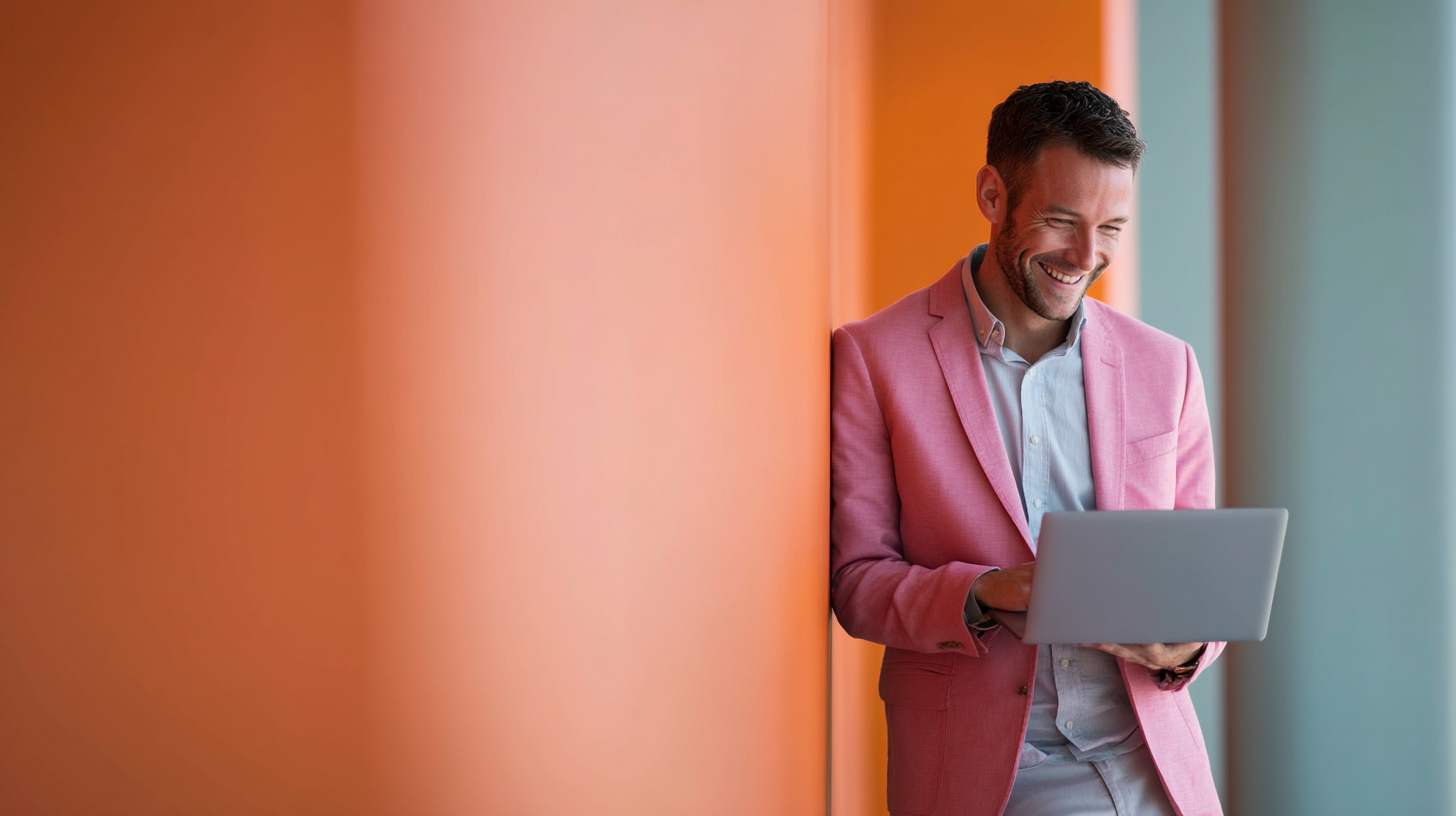 Man in pink suit using laptop.