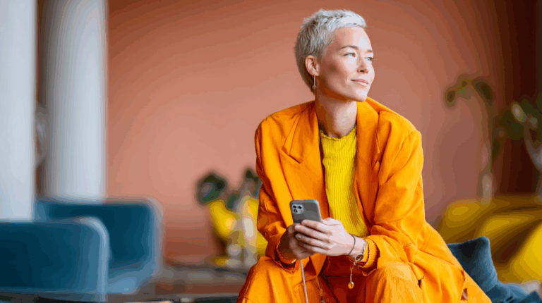 Person in orange outfit using smartphone.