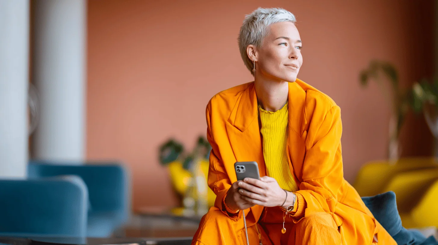 Person in orange outfit using smartphone.