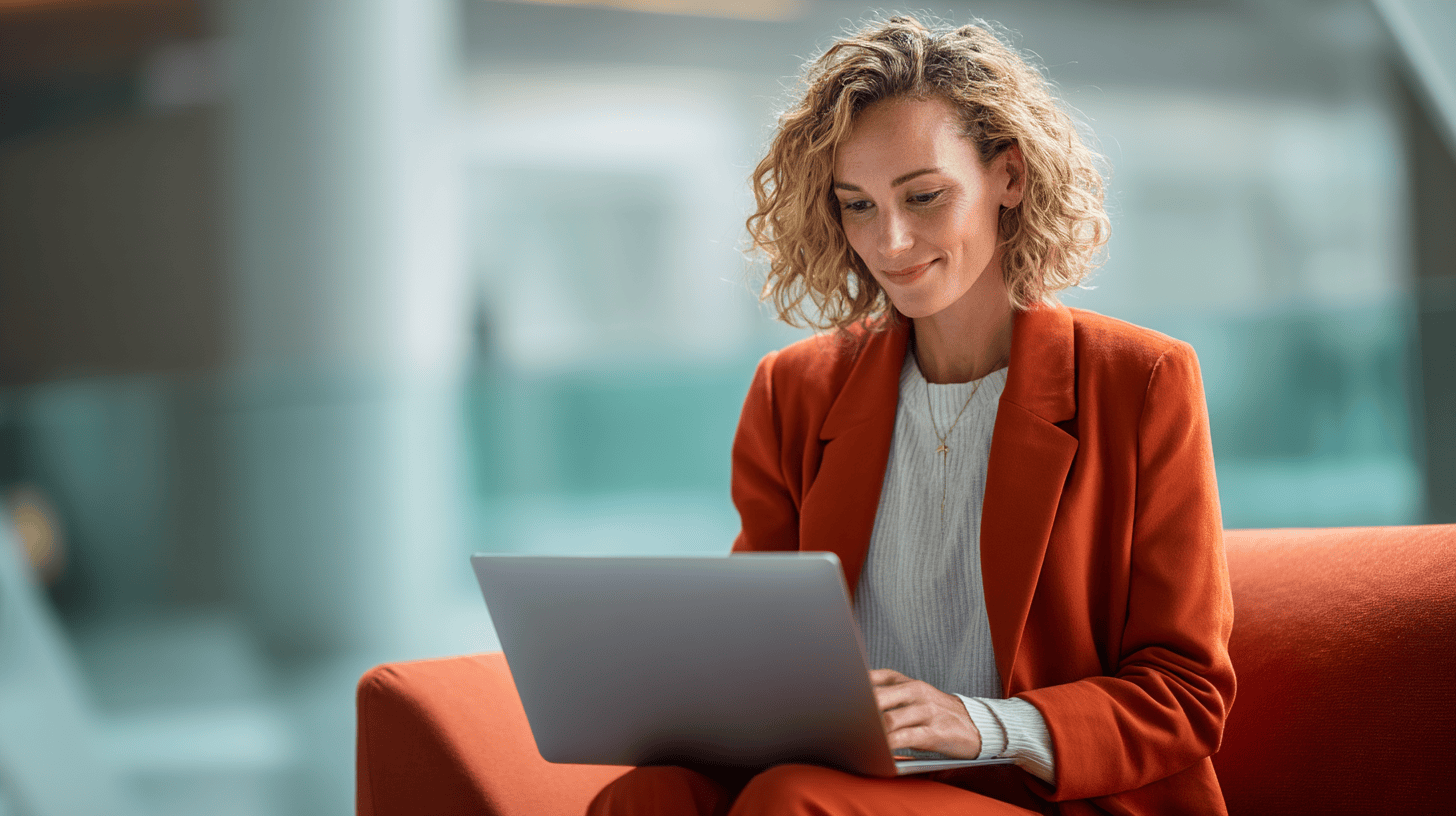 Person working on laptop in orange suit.