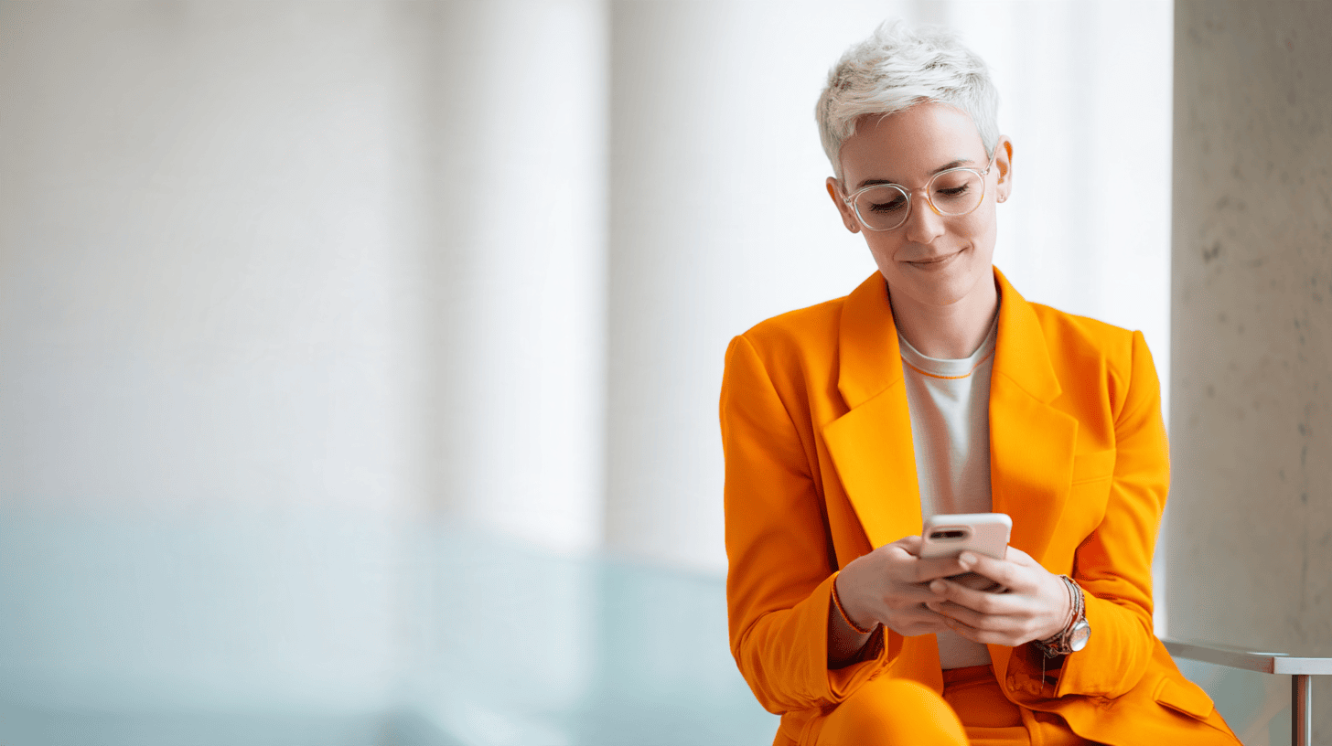 Woman in orange suit using smartphone