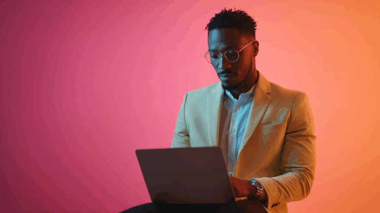Stylish young man working on a laptop in colourful professional setting for marketing solutions.