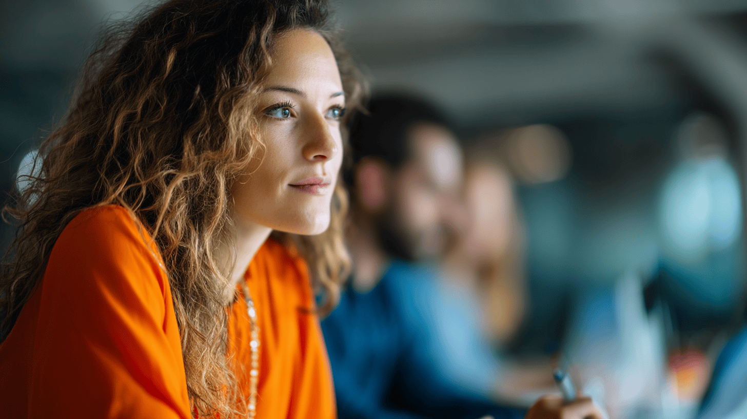 A woman with curly hair wearing an orange blouse looks thoughtfully to the side, with blurred figures in the background.