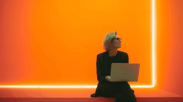 a woman sitting on a bench with a laptop